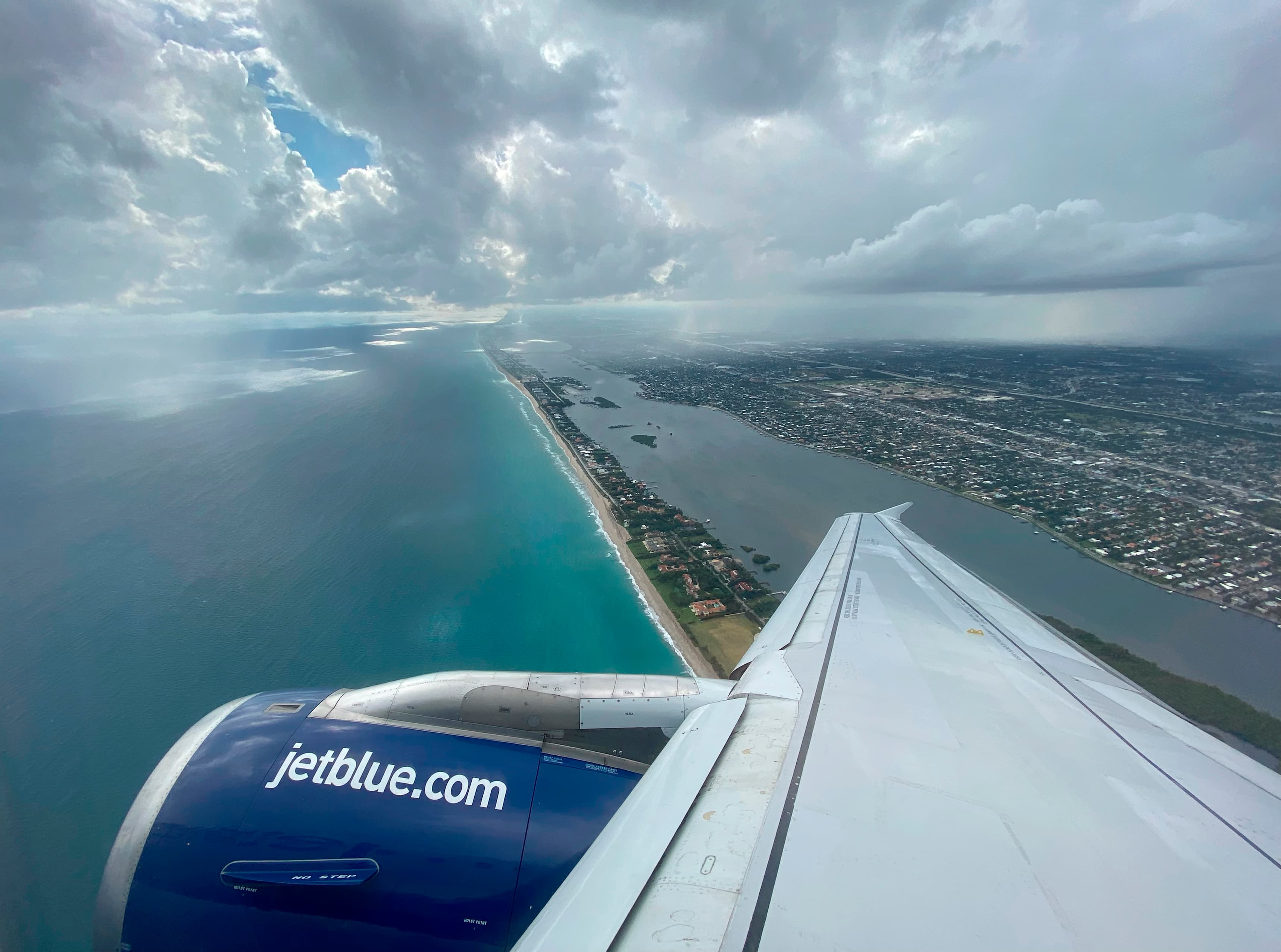 Wing of JetBlue airplane over beach