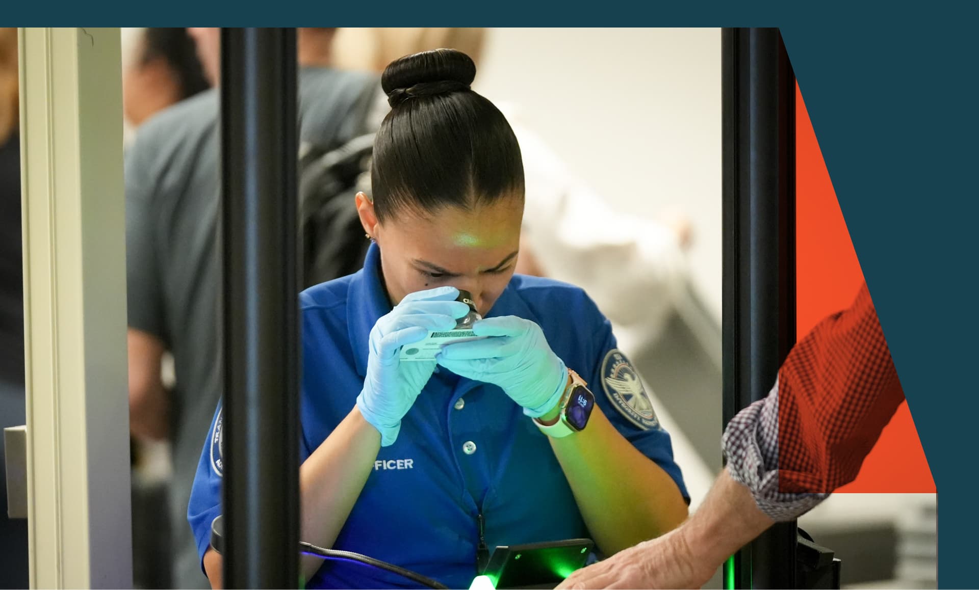 TSA officer checks identification at an airport.