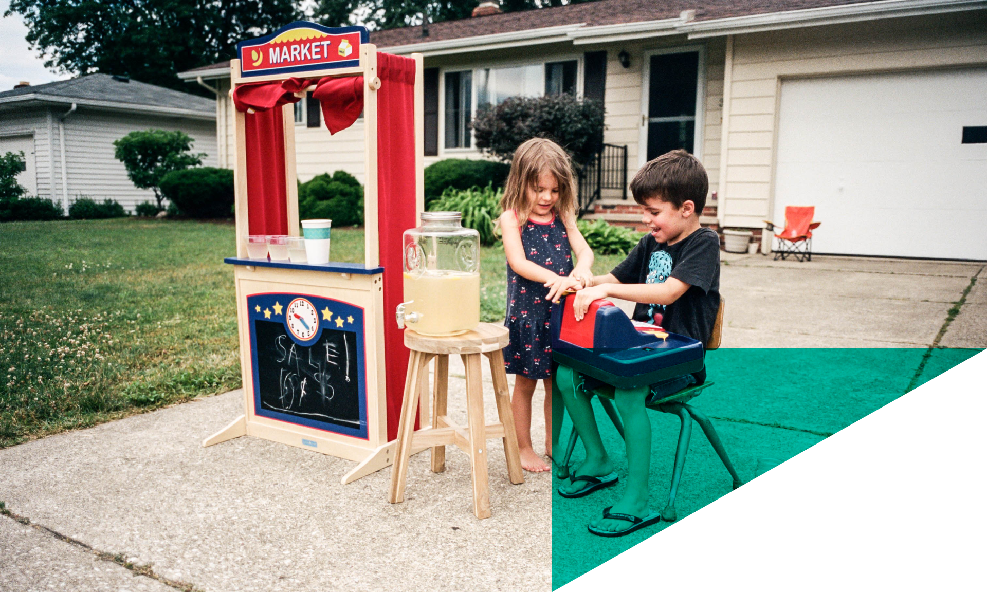 two children setting up a lemonade stand in driveway