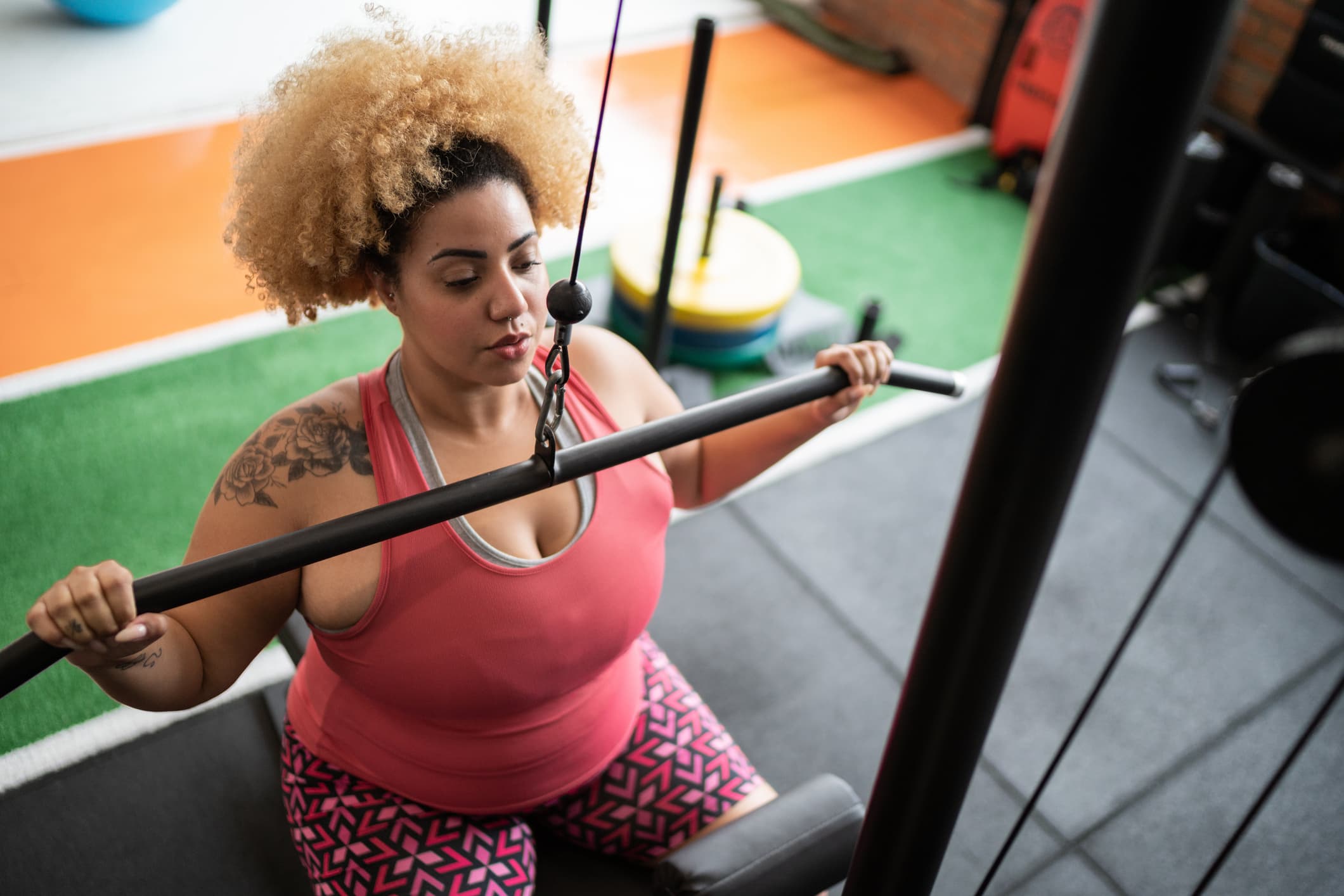 A woman working out on a weight machine at the gym