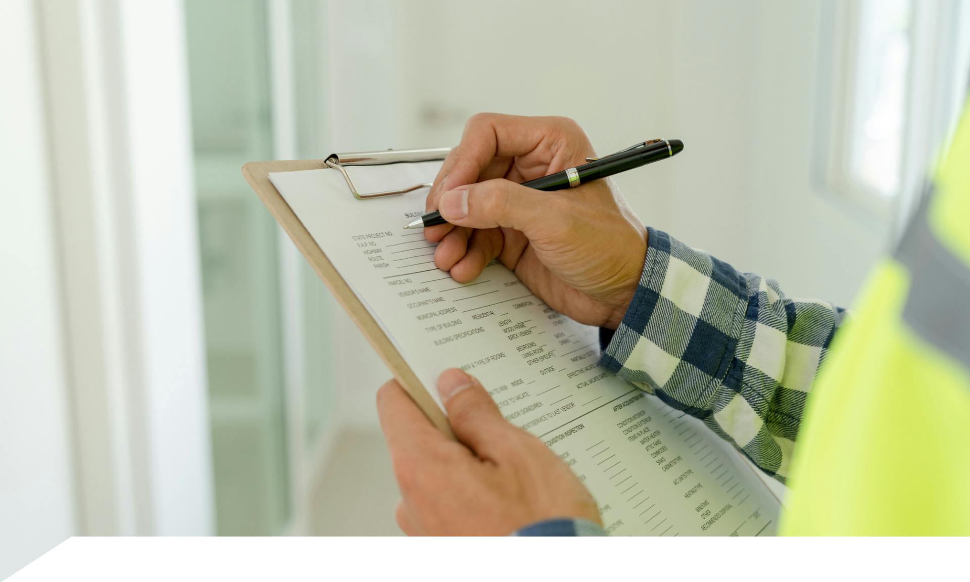 stock image of hand filling out paperwork on clipboard