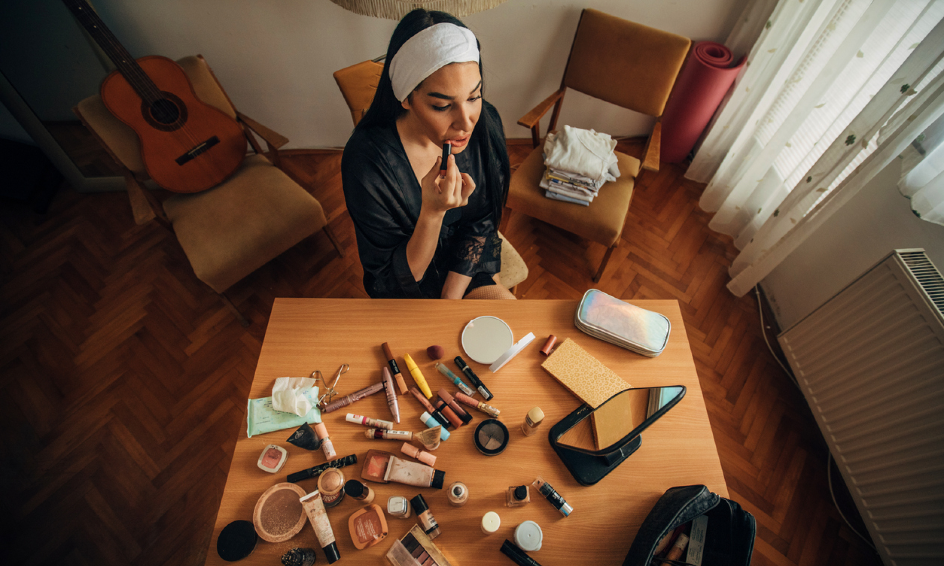 A woman doing her makeup at a table