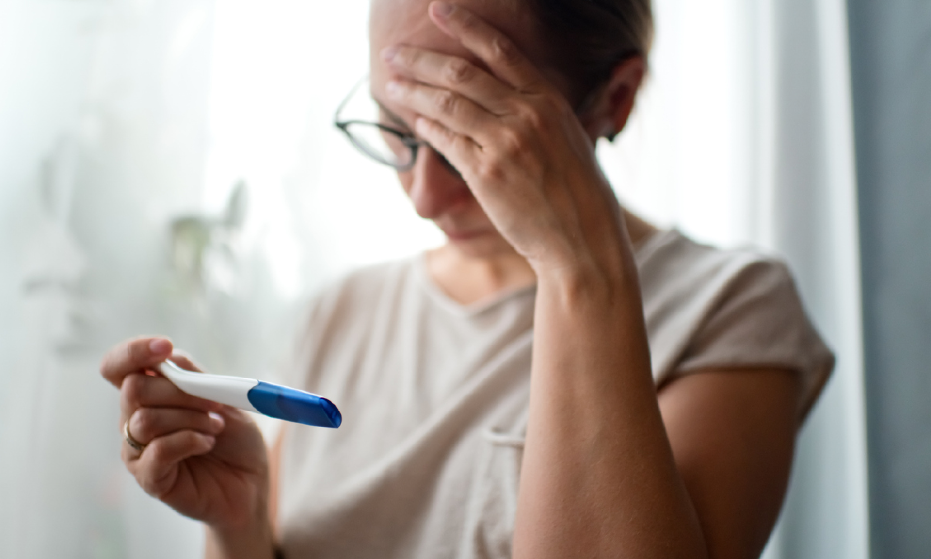 Woman looking at menopause test with her hand on her head