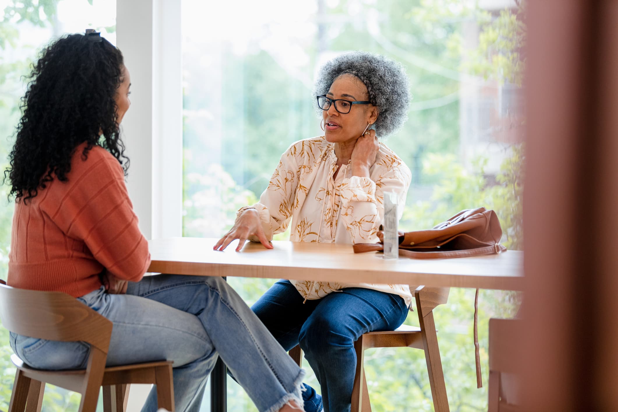 two women talking at a table