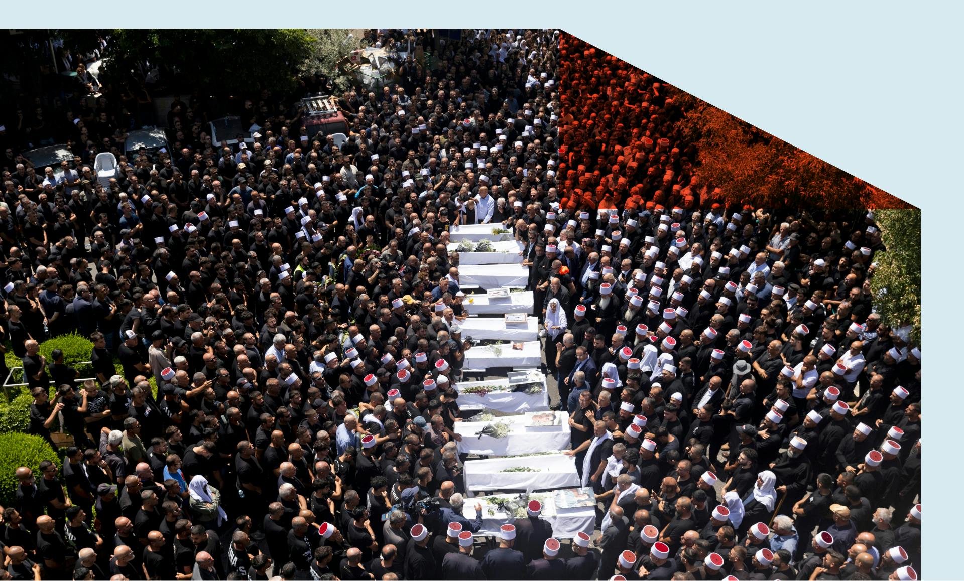 Mourners attend a funeral for ten of the victims of yesterday's rocket