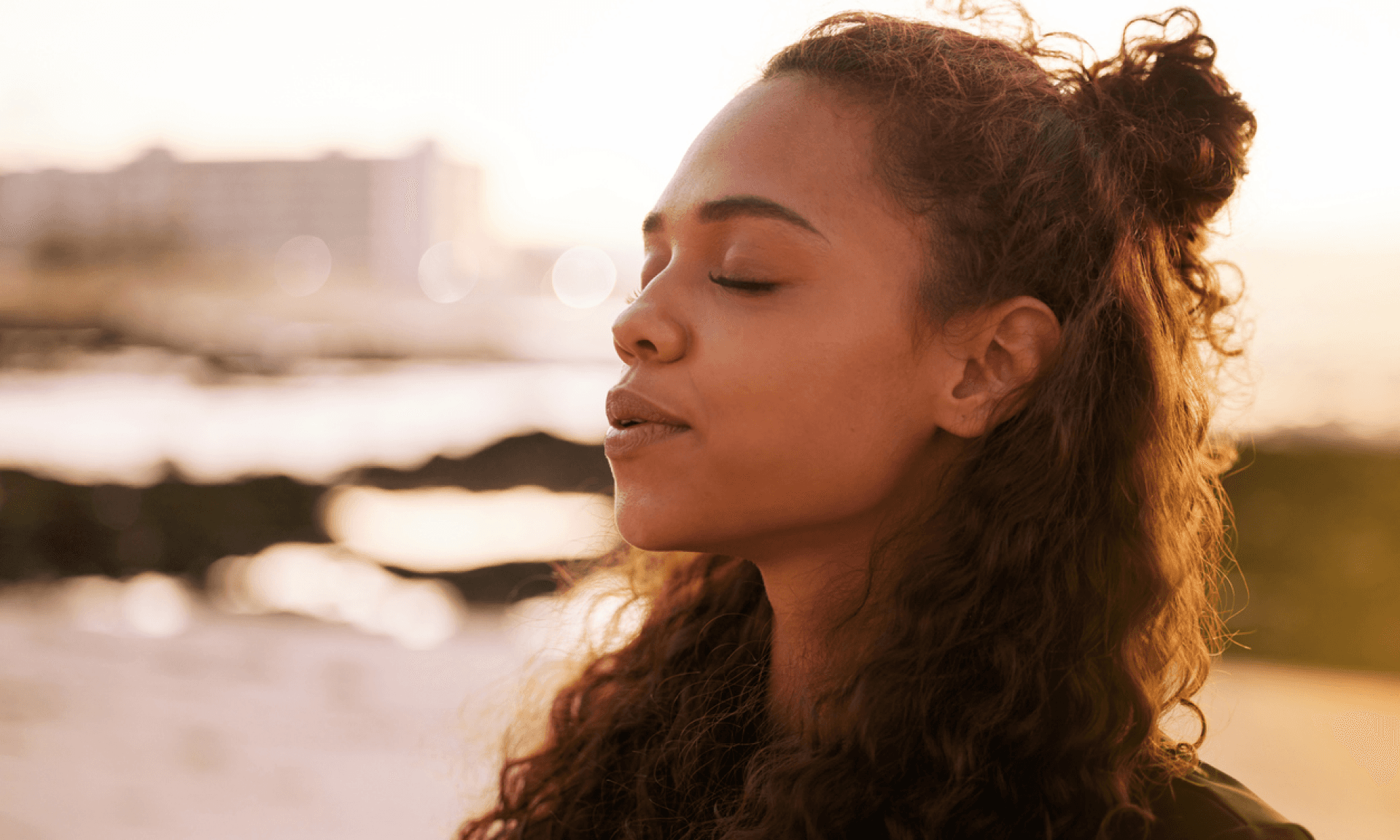 A woman with her eyes closed taking a deep breath