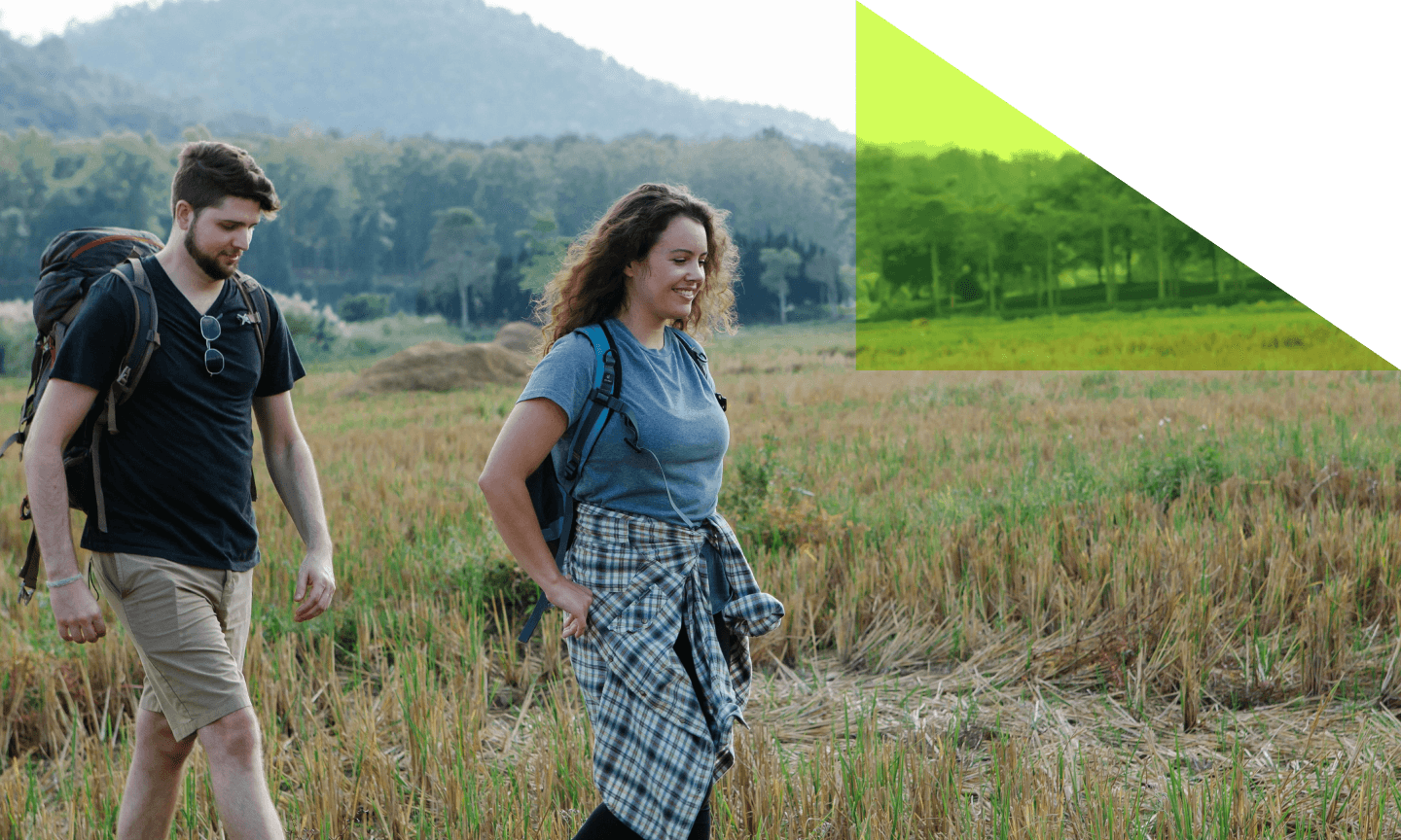 A man and a woman hiking in a field