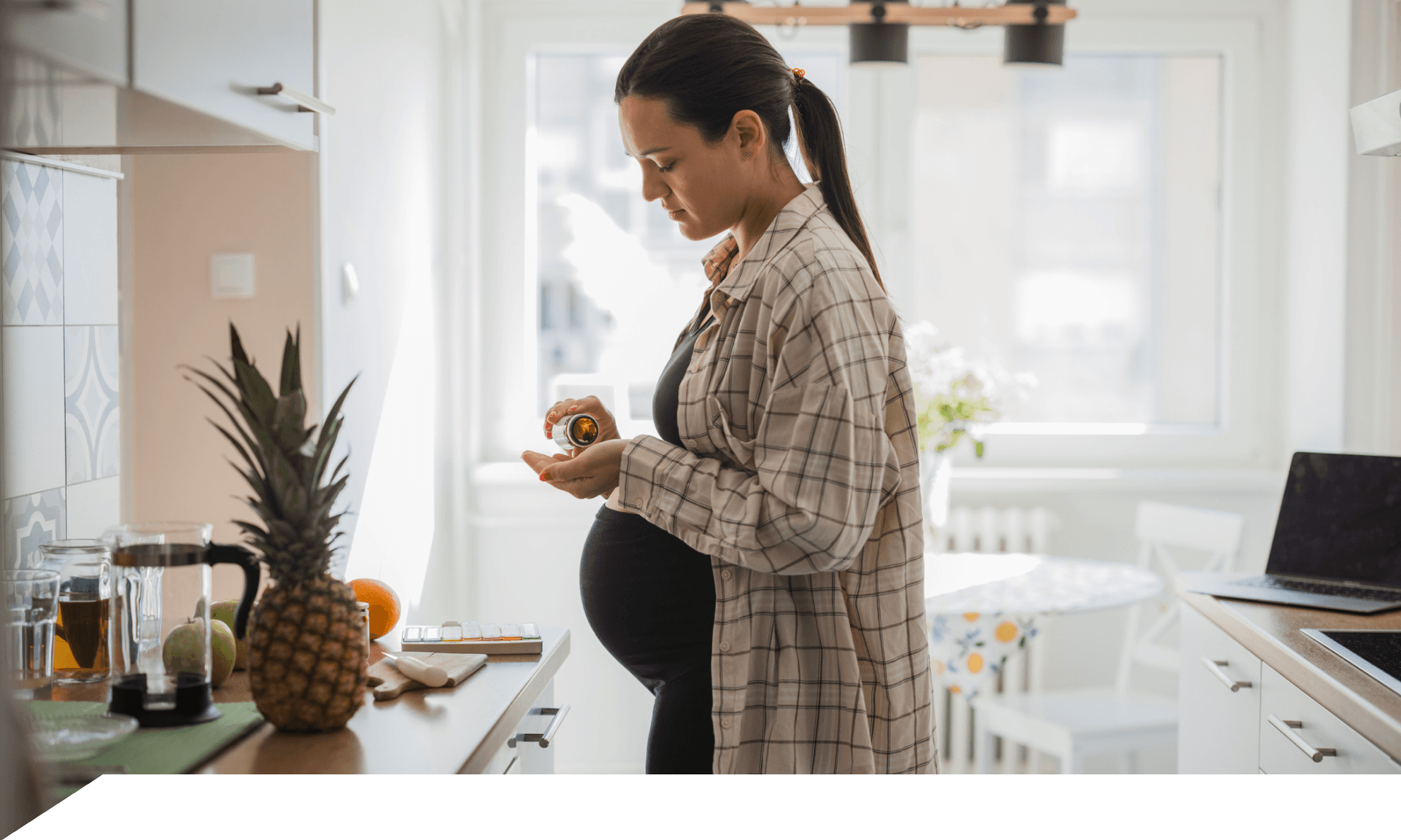 A pregnant woman pouring supplement pills into her hand