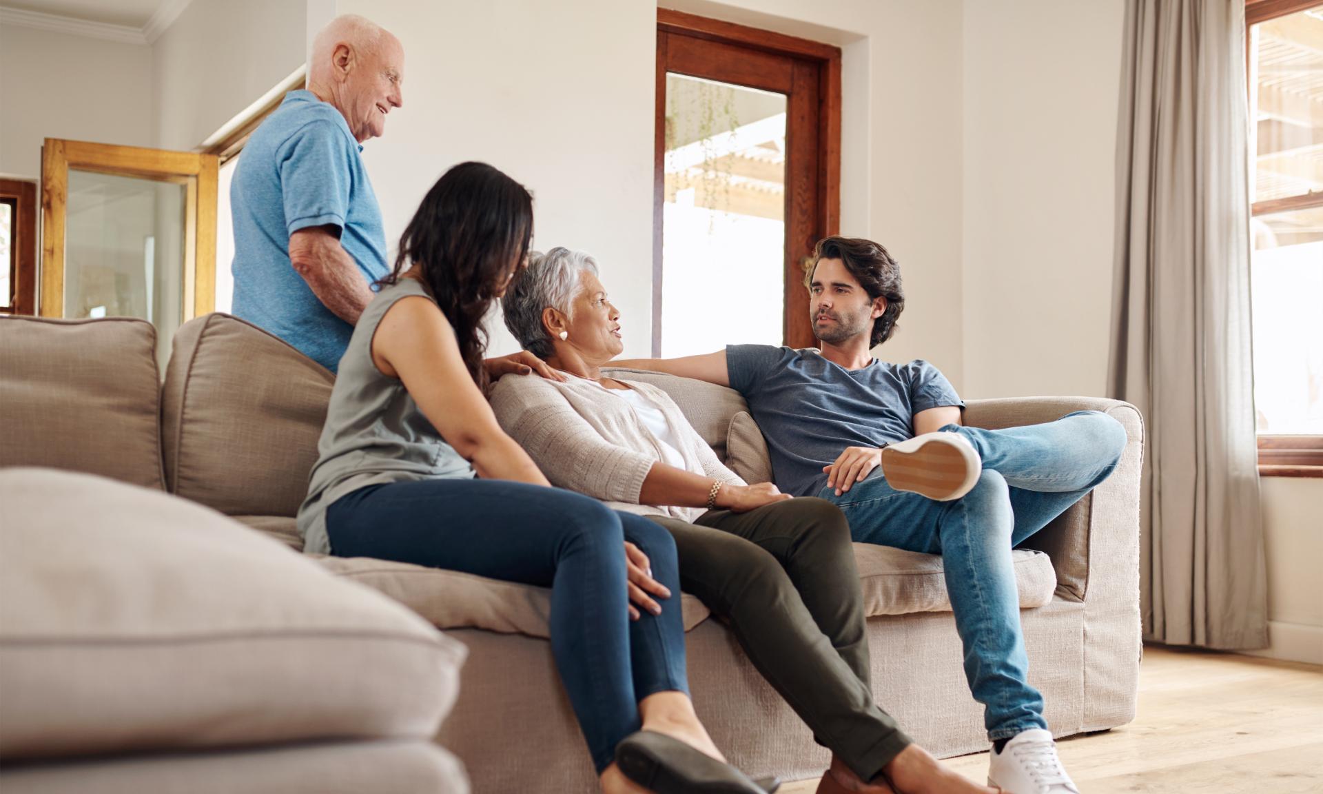 A young couple and older couple talking at home