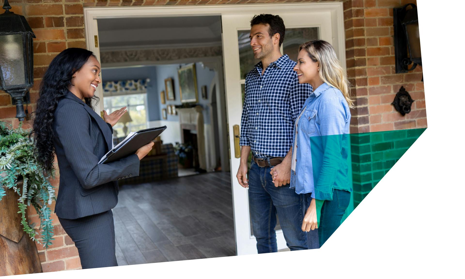 couple talking to agent in front of house