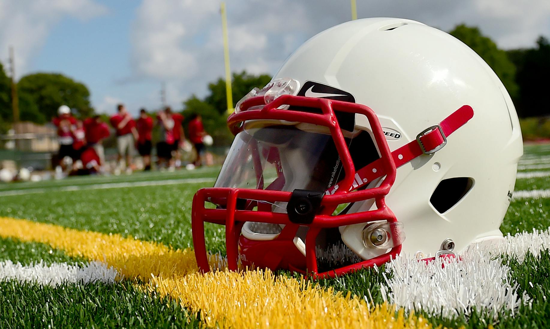 A football helmet lies on the ground.