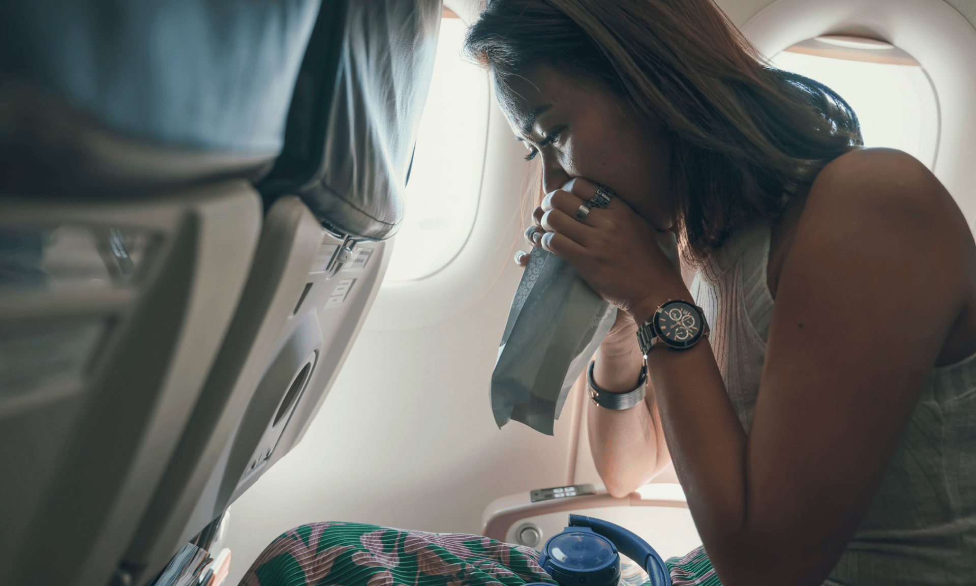 A woman breathing into a bag on a plane