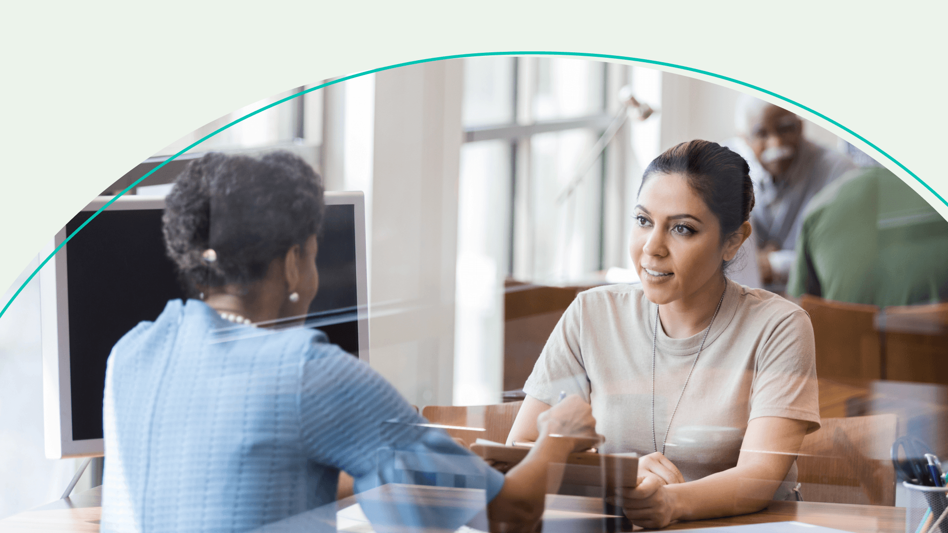 two women speaking at a table