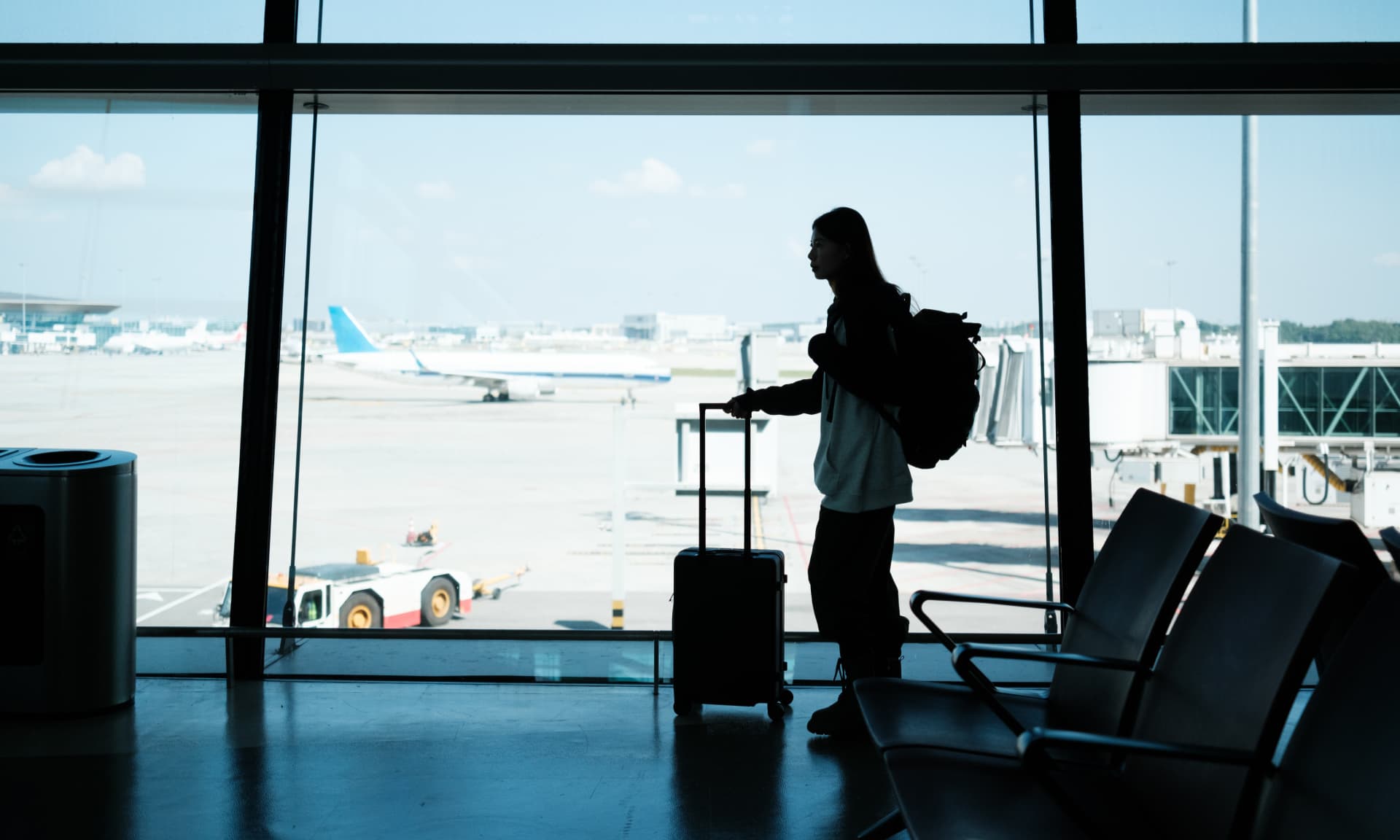 Woman walking through airport with suitcase
