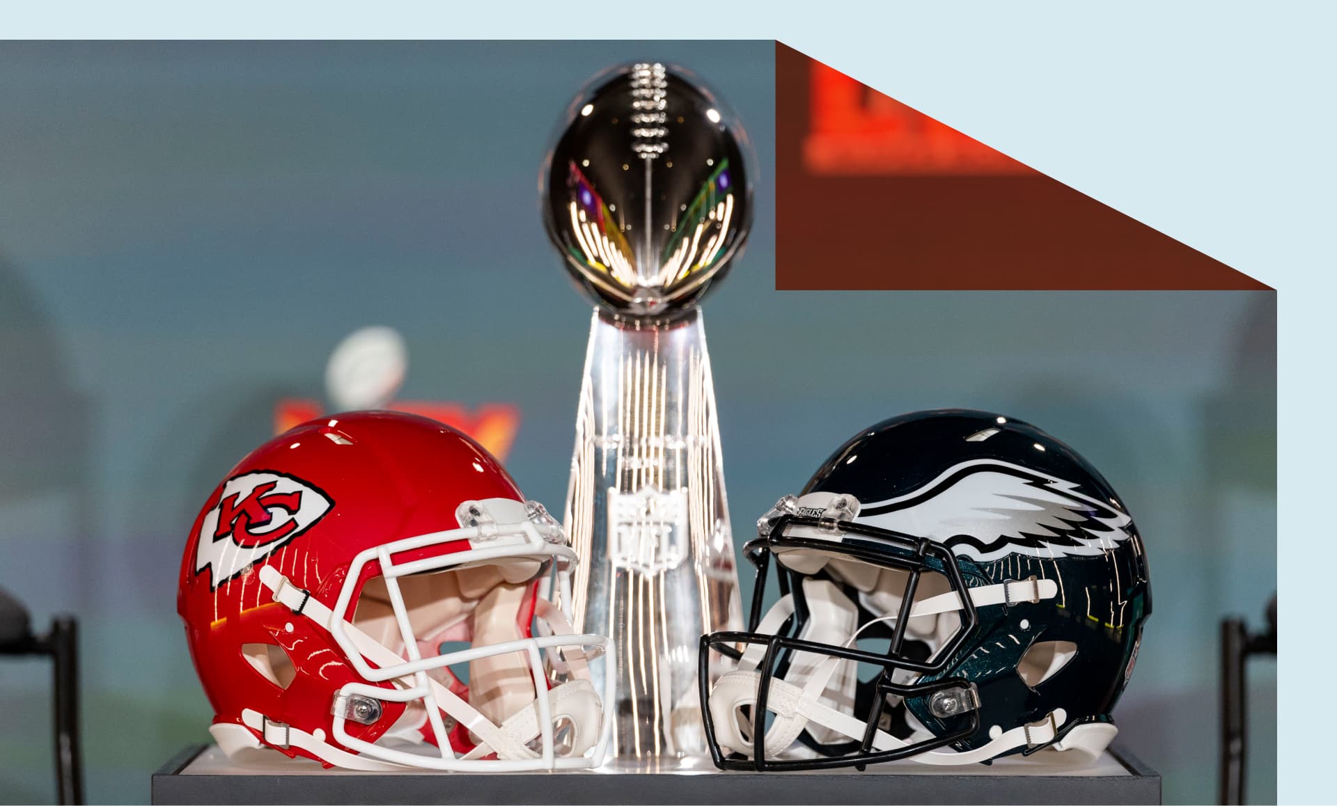 detail shot of the Lombardi Trophy next to Kansas City Chiefs and Philadelphia Eagles helmets