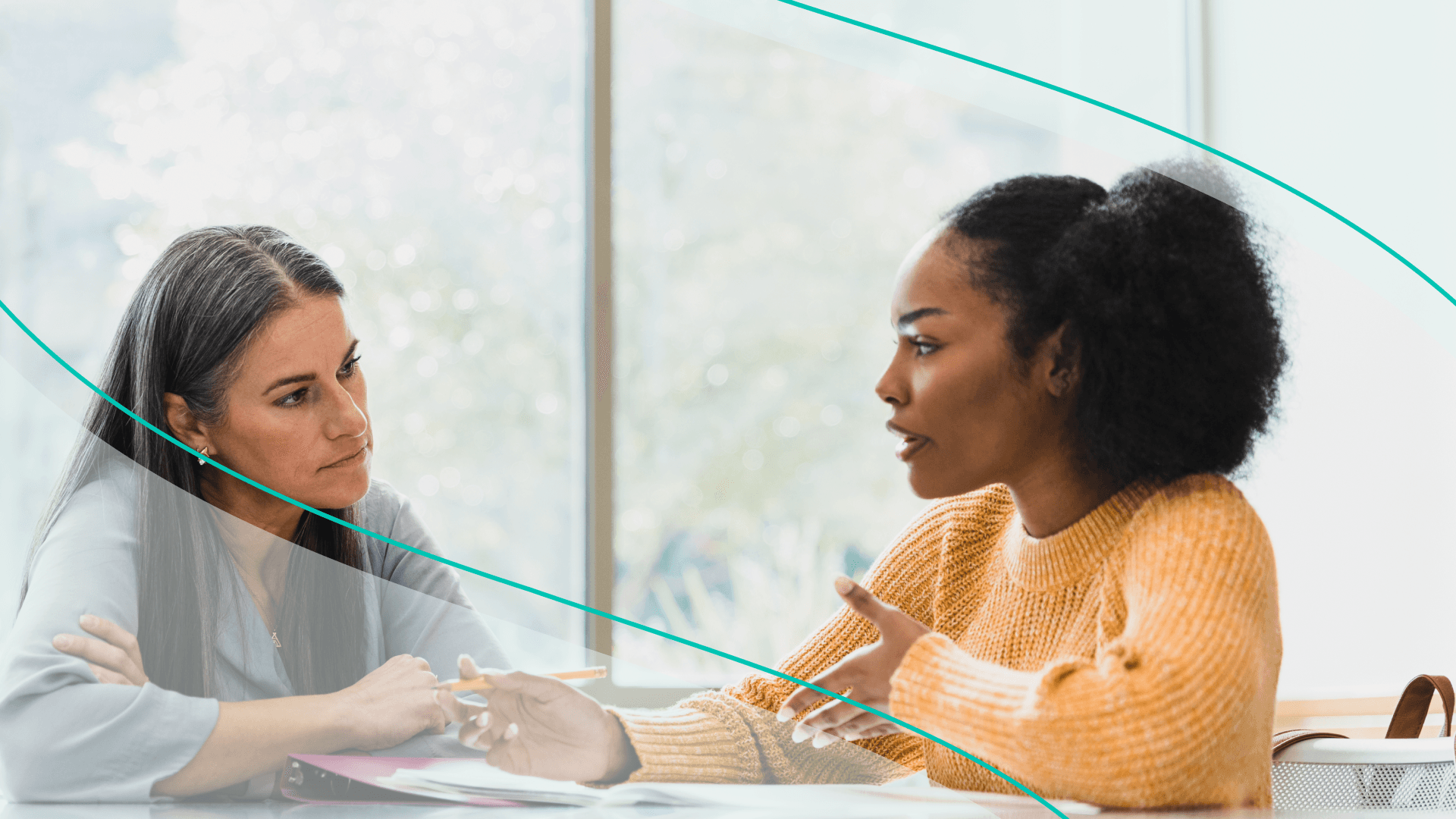 two women speaking at a table